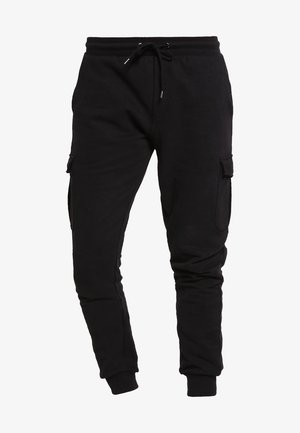 Musthave mustripsid joggers, kitsas räti ja kummiga vöökoht, külgedel kahekordsed taskud. Sile tekstuur ja elastsed sääreotsad.