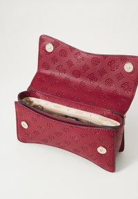 Portafoglio in pelle rossa con motivo impresso, due scomparti, con chiusura a zip e a scatto. Interno foderato in tessuto beige.