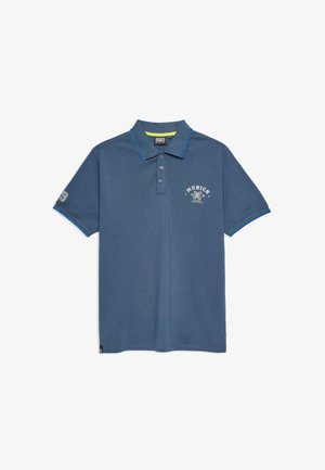 Polo de color azul oscuro hecho de una mezcla de algodón, con cuello, tapeta de tres botones y un estampado en el pecho que dice "Múnich 1939". Acentos azules en las mangas.