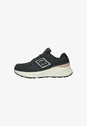 Mustat sneakersit, joissa on teksturoitu pinta ja valkoinen 'B' logo. Paksu valkoinen välipohja, harmaat yksityiskohdat ja kestävä kumipohja.
