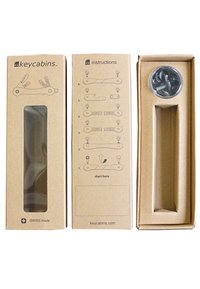 Multiverktygspaket med brunt kraftpapper, genomskinlig visningsfönster och tryckta monteringsanvisningar. Innehåller en rund behållare för hårdvara.