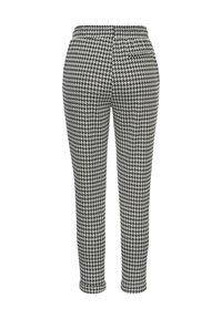 Čierno-biele nohavice s vzorom houndstooth, s elastickým pásom, priliehavým strihom a dĺžkou po členky. Vhodné na neformálne aj formálne nosenie.