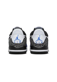 Fekete, fehér és szürke sportcipő, amely texturált középtalppal, kék díszítéssel és egy kiemelkedő Jumpman logóval rendelkezik a saroknál.