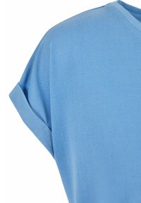 Lagana svijetloplava majica kratkih rukava s okruglim izrezom, mekani pamuk i detalji s preklopnim manžetama. Glatka tekstura s opuštenim krojem.