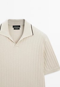 Polo beige à manches courtes côtelé avec col rabattable orné d'une bordure foncée, de Massimo Dutti, en 100 % coton.