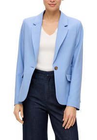 Blazer bleu clair en tissu lisse, avec des revers, une fermeture à un bouton et des poches latérales. Porté sur un haut blanc.