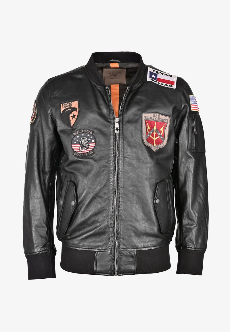 Zwarte leren bomberjack met rits, geribde manchetten en meerdere patches met emblemen en tekst, waaronder Amerikaanse vlaggen en militaire logo's.