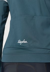 Turkusowa kurtka sportowa z białym logo "Rapha." z gładkiego materiału, z wyraźnymi szwami i dopasowanym fasonem.