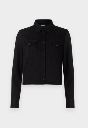 Schwarze, verkürzte Jeansbluse mit langen Ärmeln, Punktkragen, Druckknopfverschluss vorne und zwei Brusttaschen. Mit kontrastierenden Nähdetails.
