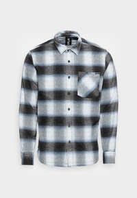 Camisa de manga larga con botones, con un patrón de cuadros azul, negro y blanco, y un bolsillo en el pecho sobre un fondo blanco.