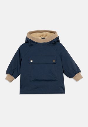 Casaco infantil azul-marinho com punhos canelados bege e forro do capuz, bolso frontal com dois botões de pressão prateados, mangas compridas.