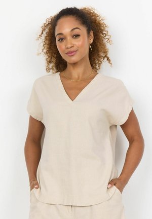 Beige top s výstřihem do V a krátkými rukávy, vyrobený z lehkého materiálu. Nabízí volný střih a jemnou texturu. Boční kapsy.