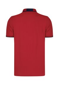 Camisa polo roja con cuello y acentos en las mangas en color marino, fabricada con tejido transpirable, que presenta un diseño clásico y un corte recto.
