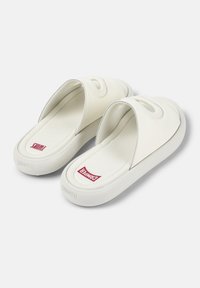 Vita slip-on sandaler i vitt med en slät yta, rundade kanter och sidoklipp. Mjukt material med en vadderad sula och logotyp.