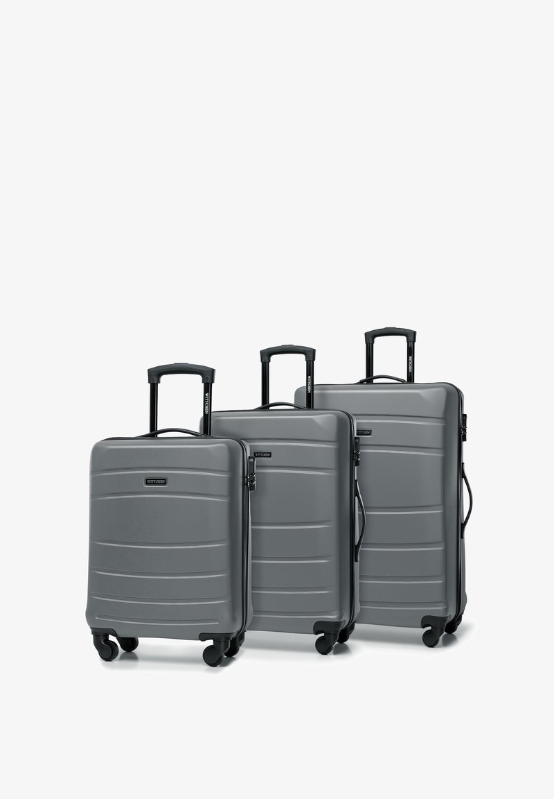 Tres maletas rígidas grises de diferentes tamaños con rayas texturizadas, asas telescópicas y cuatro ruedas negras para facilitar la movilidad.