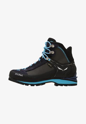 Botas de caminhada pretas e azuis com parte superior em malha, biqueira reforçada e atacadores turquesa. Apresentam sola de borracha com grip texturizado e detalhes em metal.