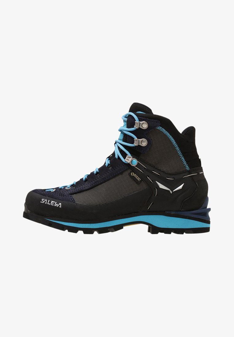 Botas de caminhada pretas e azuis com parte superior em malha, biqueira reforçada e atacadores turquesa. Apresentam sola de borracha com grip texturizado e detalhes em metal.