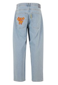 Hellblaue Denim-Jeans mit lockerer Passform, die ein rot-gelbes gesticktes "Home Boy"-Logo auf der rechten Gesäßtasche präsentieren.