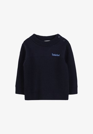Pull en tricot bleu marine avec un corps texturé, col et poignets côtelés, et deux accents de boutons sur l'épaule. Présente le logo Timberland en bleu clair.