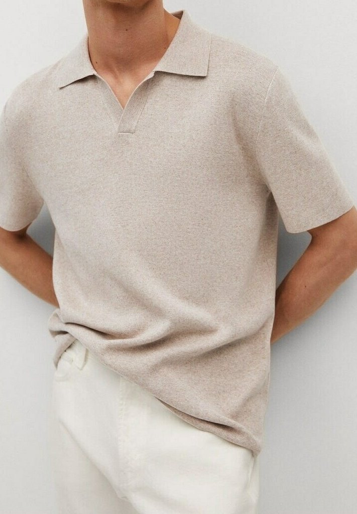 Polo beige à manches courtes avec une texture douce, un col et une patte de boutonnage, associé à un pantalon de couleur claire.