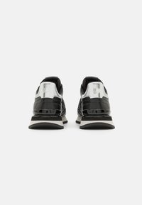 Sneakers neri con accenti argentati, dettagli in pelle verniciata, pannelli in rete e una suola spessa con una striscia bianca. Logo presente sul tallone.