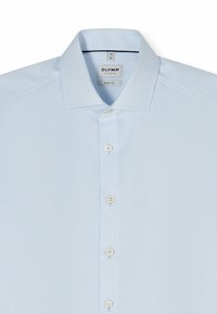 Chemise homme bleu clair à boutons, col pointu, tissu texturé et étiquette « Olymp Level Five Body Fit » à l’intérieur du col.