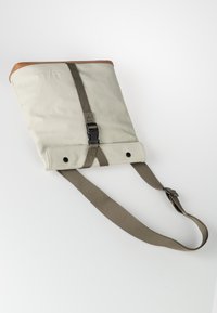 Grau, aus Stoff gefertigte Tasche mit braunen Lederakzenten, verstellbarem Tragegurt, gefaltetem Design, Kunststoffschnalle und Druckknöpfen am Boden.