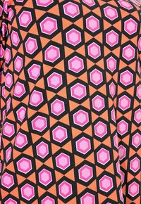 Tiskovaná látka s geometrickým vzorem v oranžové, černé a různých odstínech růžové. Design zahrnuje osmiúhelníky a trojúhelníky.