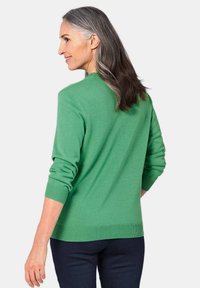 Grüner Strickpullover mit lässiger Passform, gerippten Bündchen und Saum. Weiche Textur, runder Ausschnitt und ein gleichmäßiges, glattes Strickmuster.