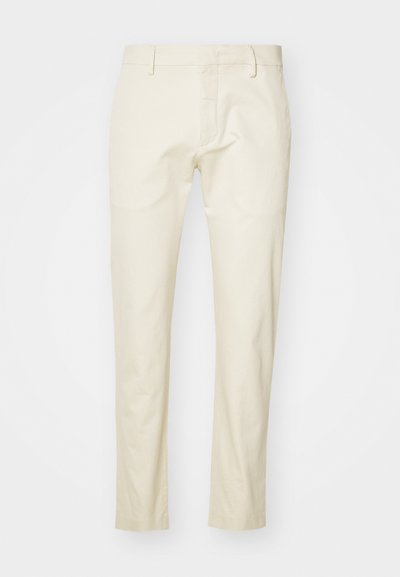 Beige bomullbyxor med rak bendesign, framdragkedja och platta fickor. Texturerad tyg med en slät yta.