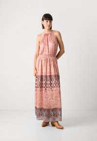 Robe maxi en corail clair avec un col halter. Présente un corsage froncé, une taille élastique et des motifs floraux dans des tons plus foncés à l'ourlet.
