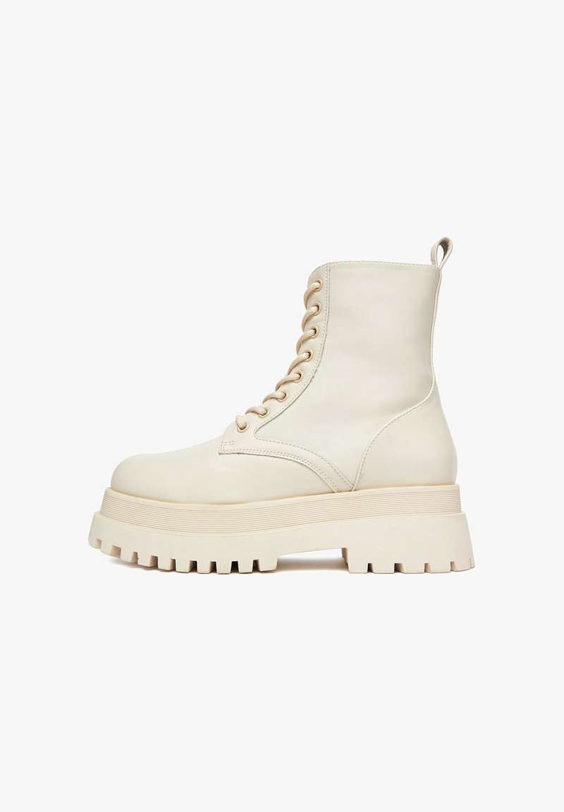 Bieli ādas potīšu zābaki ar biezu platformas zoli, ar apaļām auklām un cilpu aizmugurē. Zoles teksturētais protektors.