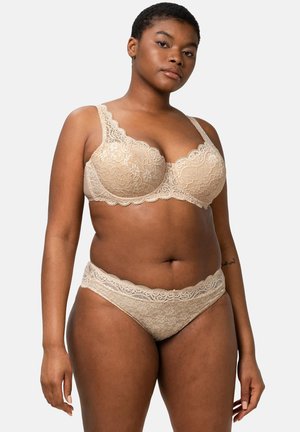 Beige pitsimalliset alusvaatteet, joissa on rintaliivit, joissa on aaltoilevat reunat, ja yhteensopivat hipster-housut, molemmat kukkakuosiset ja pehmeät.
