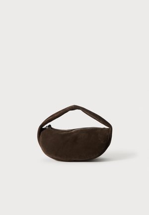 Borsa a mano in suede marrone con forma curvata, manico spesso e chiusura con zip. Presenta una texture morbida e un design minimalista.