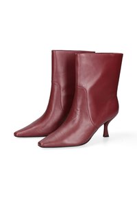 Bottines en cuir bordeaux à bout pointu et à talon fin. Texture lisse avec un minimum de coutures pour un look raffiné.