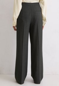 Hoge taille donkergrijze pantalon met verticale streepjes, relaxed fit, enkele achterzak en een gladde stoftextuur.