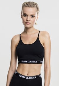 Crni sportski top kratkih rukava napravljen od rastezljivog materijala s uskim naramenicama i elastičnom trakom sa logom "URBAN CLASSICS" u bijeloj boji.