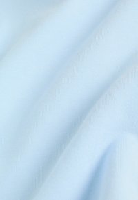 Tissu bleu clair à texture lisse, présentant un motif côtelé fin. Le matériau semble doux et légèrement extensible.