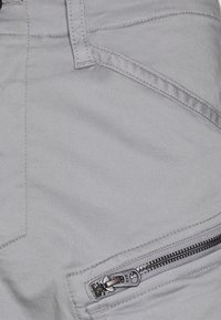 Gray cargo pants featuring smooth fabric, zipper pocket detail, straight cut, and prominent stitching along the pockets.