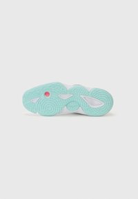 Semelle de chaussure de sport blanche avec une surface en caoutchouc vert menthe texturé et un point d'accent rouge. Présente des motifs de vagues uniques et des découpes.