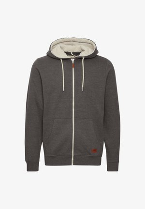 Hallhalli halljope, millel on kreemivärvi fliisvooder, kaks esistaskut, reguleeritav kapuuts ja pruuni nahast logo silt alumises paremas nurgas.