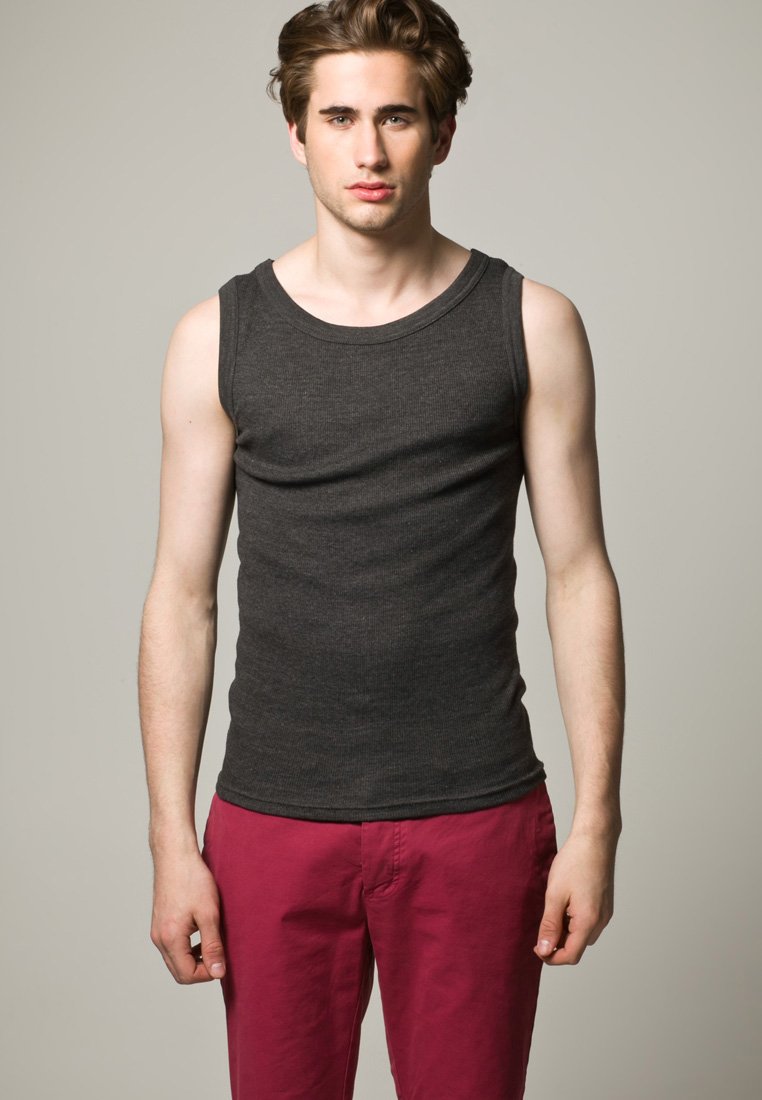 Hall grii ribidega tank top, millel on avar kaelus. Mudel kannab seda kontrastsete roosa värvi pükstega. Kangas näeb välja pehme ja tal on keha lähedane lõige.