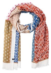 Écharpe colorée présentant des motifs floraux et géométriques en rouge, bleu, beige et blanc, avec un tissu léger et texturé et des bords effilochés.