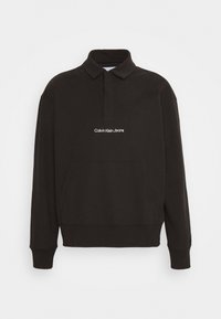 Black sweatshirt with a polo collar, long sleeves, and a front pocket. Features white "Calvin Klein Jeans" logo embroidered on the chest.
