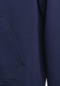 Marinblå sweatshirt med ett mjukt, texturerat tyg. Har en känguruficka och ribbade ärmslut. Enkelt design utan synliga logotyper eller mönster.