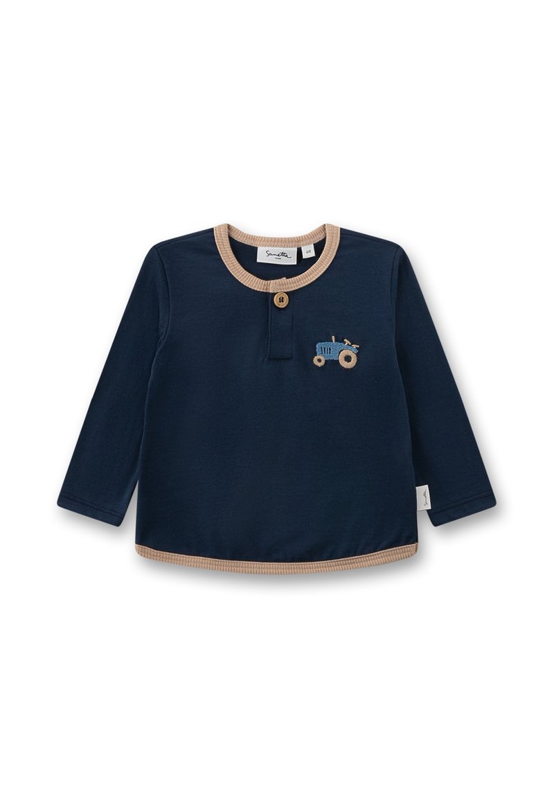 Marineblaue Langarmbluse mit beigem Besatz und Knopfleiste. Mit einem gestickten blauen Traktordesign auf der linken Brust. Aus weichem Baumwollmaterial.
