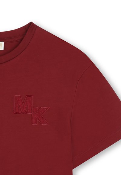 T-shirt bourgogne avec des lettres "MK" superposées brodées sur le côté gauche de la poitrine, manches courtes et col rond.