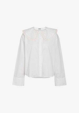 Valge pika varrukaga särk, millel on suur, tikitud lainelise äärega krae, millel on õrn roosa ääristus. Lihtne kangas, veidi lõdvestunud istuvus, nööpkinnitusega.