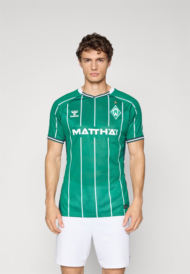 Green soccer jersey with white vertical stripes and collar. Features a logo on the left chest and a brand name across the front.