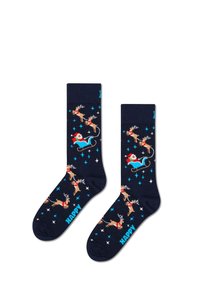 Calcetines marino con un patrón de renos y Papá Noel en un trineo, con acentos de estrellas azules y blancas. El texto en los calcetines dice "FELIZ".